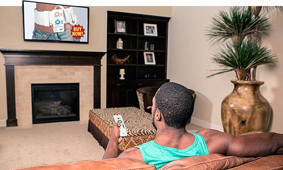 Мужчина просматривает телевизор с рекламой тренажера для сжигания жира фото