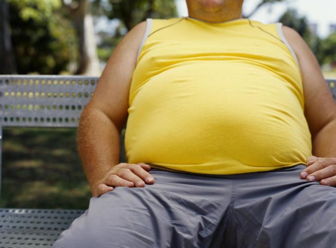 толстый мужчина в желтой майке на скамейке